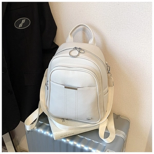 Detail of white lychee grain leather backpack with silver zippers and fabric straps