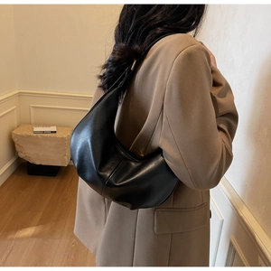Side view of black leather hobo bag on shoulder showing large capacity and drape