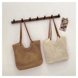 Detail of handmade woven tote bags with leather handles in khaki and cream colors