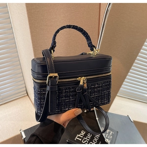 Détail du sac boîte bleu marine montrant la texture tweed et la fermeture dorée chic