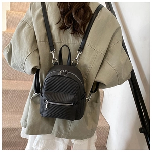 Detail of black mini backpack featuring twill texture fabric and silver metallic zippers
