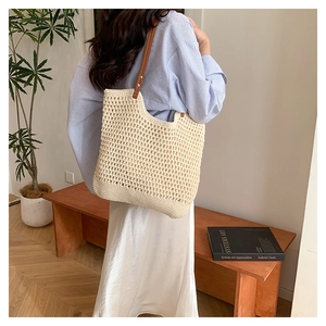 Close-up of hollow woven tote bag with premium brown leather handles and rivets