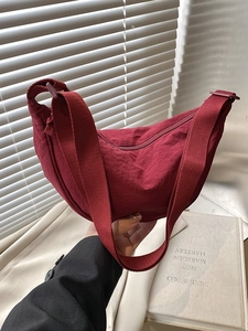 Burgundy nylon hobo bag in a stylish half-moon shape with a wide shoulder strap