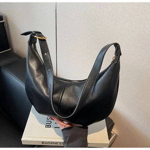 Detail of black matte leather hobo bag with adjustable strap and golden metal buckle
