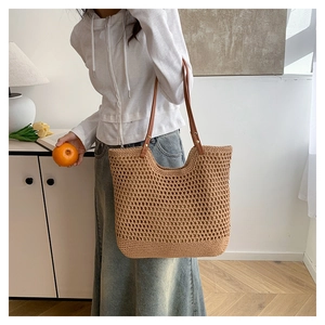Detailed texture of hollow woven beach tote bag with premium leather shoulder straps