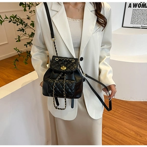 Détail du mini sac à dos noir matelassé avec chaîne dorée et fermoir rotatif élégant