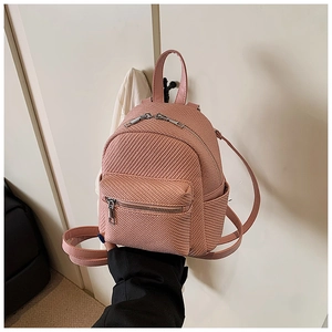 Detail showing the pink mini backpack with twill woven texture and dual zipper pockets