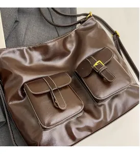 Detail of vintage brown leather tote bag with gold pin buckle pockets and glossy finish