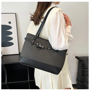 Detail der grauen Web-Tasche mit schwarzem Lederboden und metallischem Karabinerverschluss