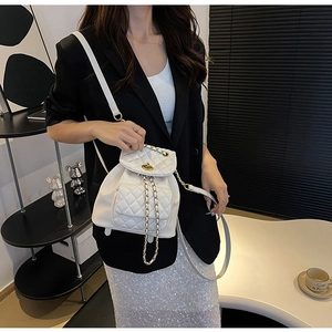 Détail du sac matelassé blanc avec bandoulière chaîne dorée et fermoir pivotant