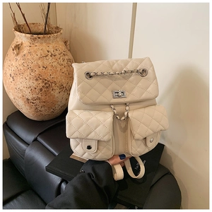 Detail of cream quilted mini backpack with chain strap and classic metal turn-lock closure