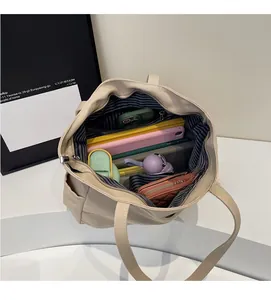 Interior view of beige canvas tote bag with striped lining and large capacity storage