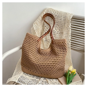 Close-up of crochet hollow tote bag with leather handles and metallic rivet details