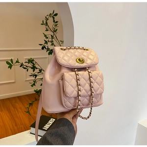 Détail du mini sac à dos rose poudré matelassé avec fermoir doré et bandoulière chaîne