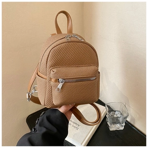 Detailed view of brown woven texture mini backpack with silver zipper and PU leather trim