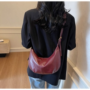 Detail of burgundy leather hobo bag showing adjustable strap and metallic buckle