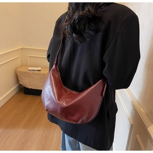 Detail view of burgundy hobo bag in oil-wax leather finish showing soft drape and texture
