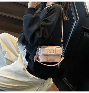 Détail du sac bandoulière tissé rose clair avec chaîne en métal et logo HIGH SIDE