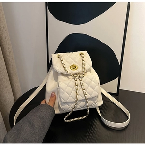 Détail du sac à dos en cuir matelassé blanc cassé avec chaîne dorée et fermoir pivotant