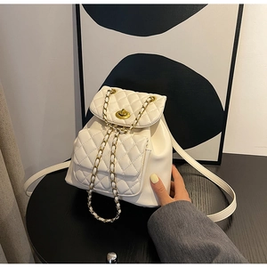 Détail du mini sac à dos matelassé blanc avec bretelles en chaîne dorée et fermoir