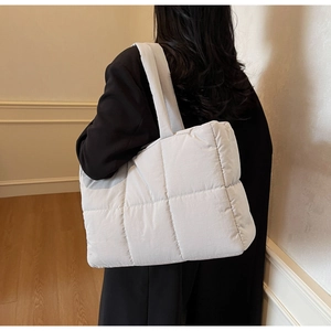 Detail of quilted cotton tote bag showing large stitching and thick padded shoulder strap