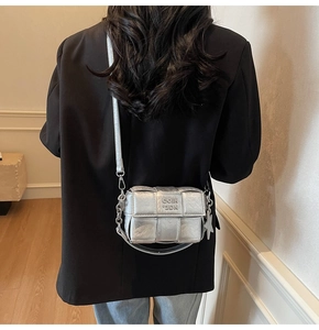 Détail du sac bandoulière argenté tressé avec texture matelassée et breloque étoile