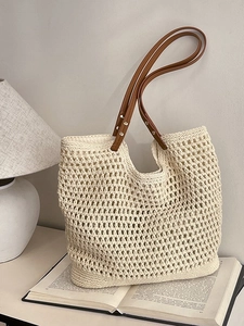 Hollow knit straw tote bag with brown leather handles for bohemian beach vacation style