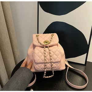 Détail d'un sac à dos rose matelassé avec chaîne dorée et fermoir pivotant élégant