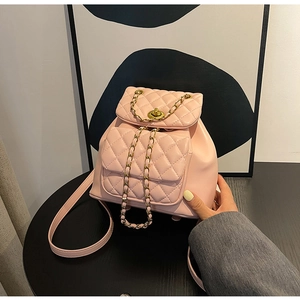 Détail du sac à dos matelassé rose avec fermoir doré et élégantes bandoulières en chaîne