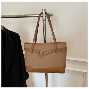 Detail der braunen Shopper Tasche mit gewebter Textur, Lederbesatz und Metallschnalle