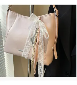 Detail of light pink bucket bag featuring white lace bow and woven rope decoration