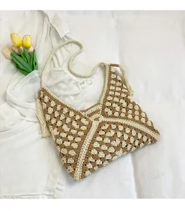Detail of crochet weave pattern with geometric color blocks and side tassels on beach bag