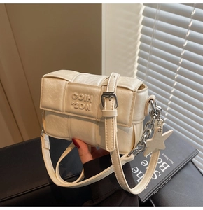 Détail du sac en cuir PU tissé blanc crème avec breloque étoile argentée et chaîne