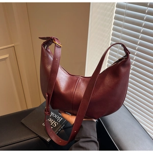 Detailed close-up of wine red hobo bag with adjustable gold buckle and smooth leather finish