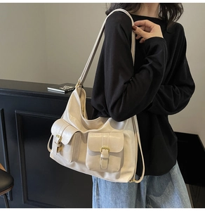 Detail of cream vintage tote bag showing front flap pockets and metallic buckles
