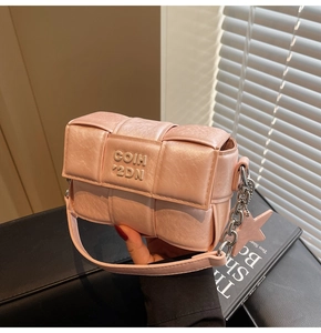 Détail du sac tressé rose avec bandoulière en chaîne argentée et charm étoile