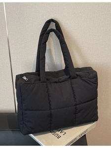 Large black quilted puffer tote bag with silver zipper and double handles for women