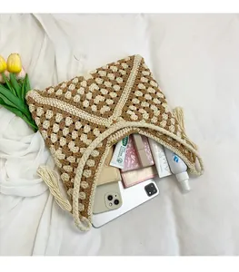 Spacious interior of hand-woven crochet bag with tassels holding daily essentials