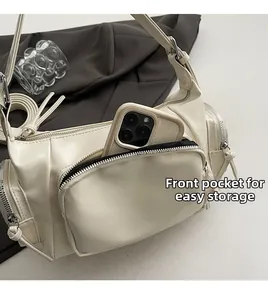 Detailansicht der cremeweißen Umhängetasche mit mehreren funktionellen Stautaschen