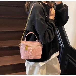 Rosa gesteppte Beuteltasche mit goldener Kette und Ledergriff an einem Model