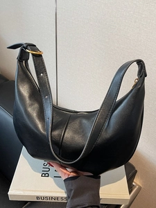 Minimalist black crescent shoulder bag with pleated faux leather and adjustable strap