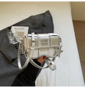 Détail d'un sac en cuir tressé argenté avec lettres gaufrées et pendentif étoile