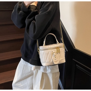 Detail der weißen gesteppten Eimertasche mit Goldkette und Doppelreißverschluss
