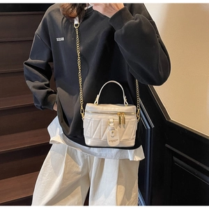 Detailansicht der weißen gesteppten Mini-Beuteltasche mit goldenem Kettenriemen-Detail