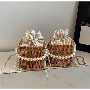 Detail of hand-woven straw bucket bag with pearl handle and canvas drawstring lining