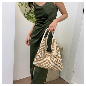 Close-up of bohemian crochet tote bag with geometric patterns and tassel detail