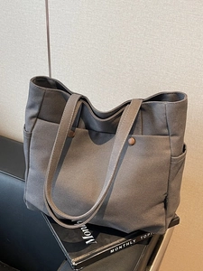 Dark grey canvas tote bag with multi-pockets and sturdy handles for casual commuting