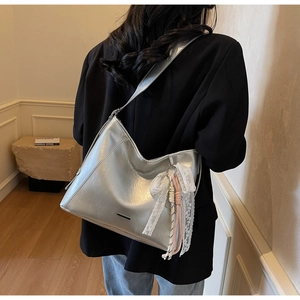 Detailed view of silver large capacity tote bag with white lace bow and fringe decor