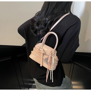 Detail of light pink shell handbag with woven rope charm and silver F pendant strap