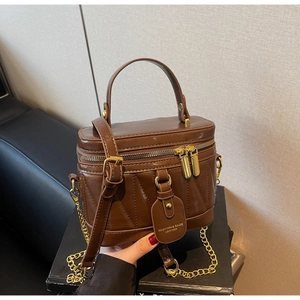 Detailansicht der braunen Retro-Box-Tasche mit goldenen Reißverschlüssen und V-Naht